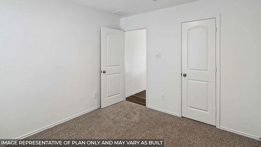 Secondary bedroom with windows, light carpet, and white walls.