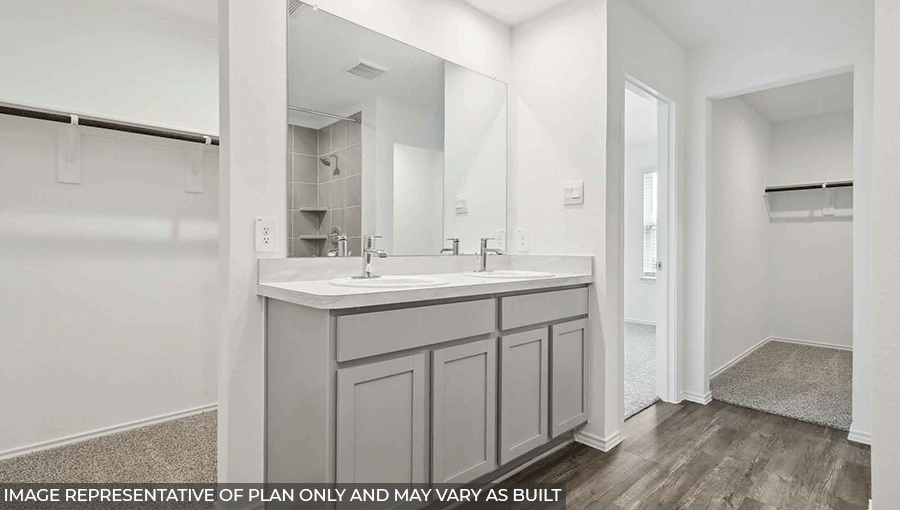 Primary bathroom with a walk-in shower, storage shelves, dual sinks, light gray cabinets, white walls, and vinyl wood flooring.