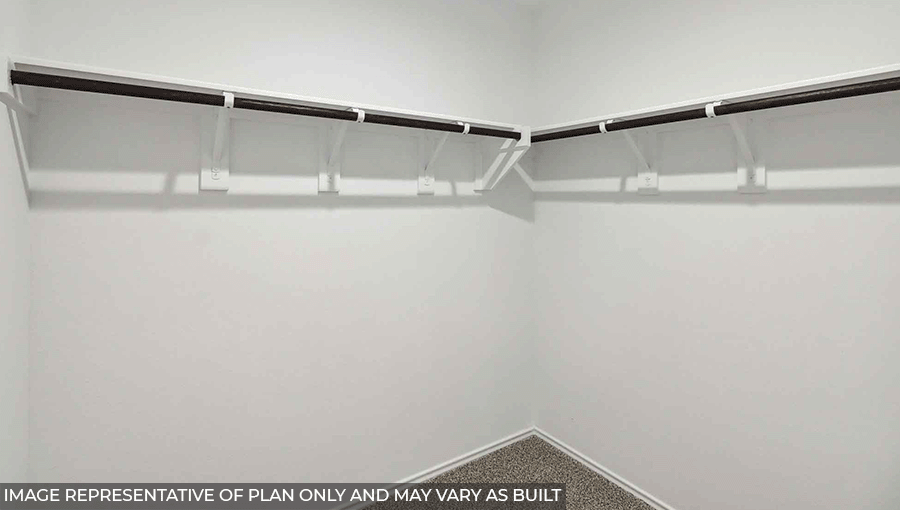 Primary closet with light carpet and white walls.