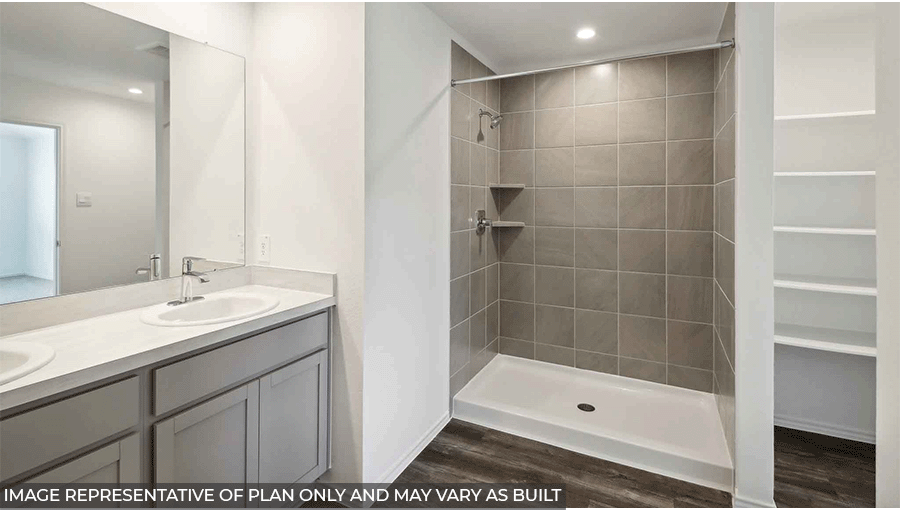 Primary bathroom with a walk-in shower, dual sinks, light gray cabinets, white counter tops, white walls, and vinyl wood flooring.