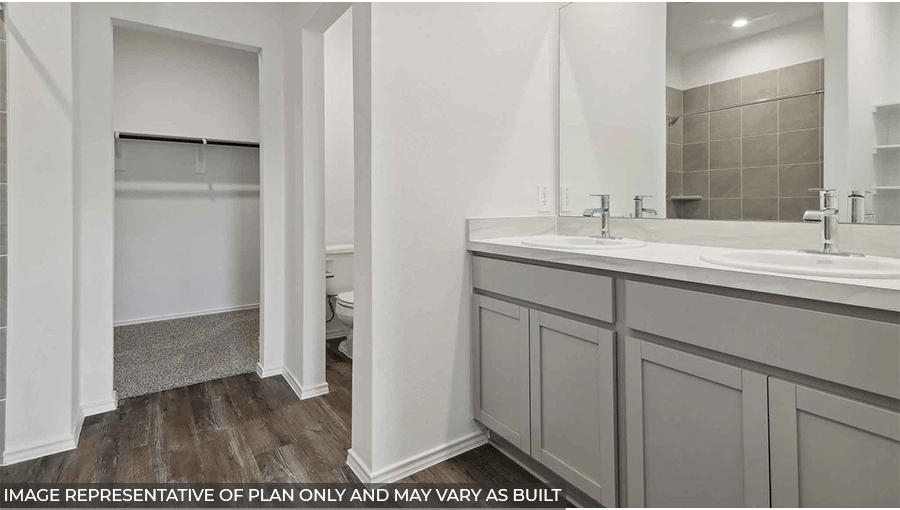 Primary bathroom with a walk-in shower, dual sinks, light gray cabinets, white countertops, white walls, and vinyl wood flooring.