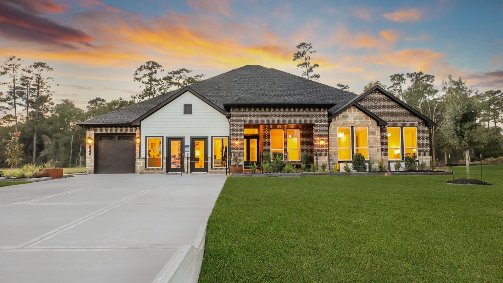 Front of the home with two tone brick, a three-car garage, and double doors.