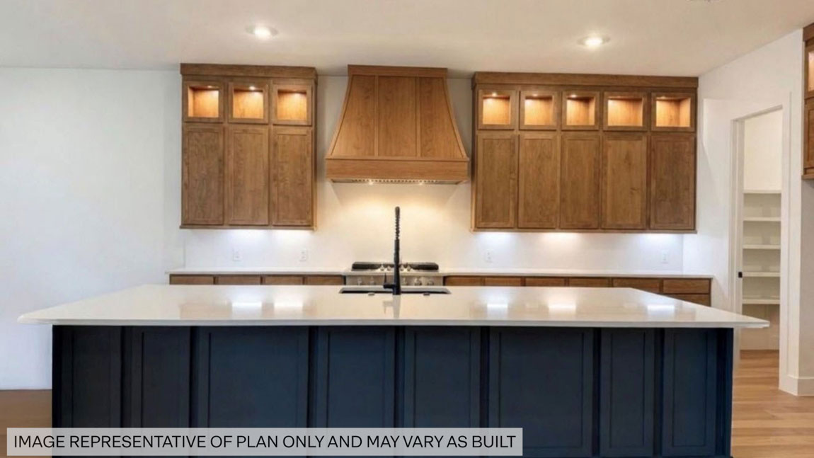 Kitchen with stainless steel appliances, quartz countertops and modern hardware and an island and vinyl floor