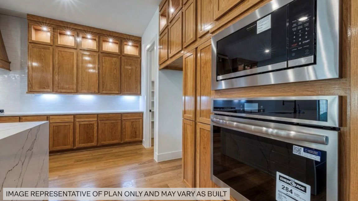Kitchen with stainless steel appliances, quartz countertops and modern hardware and an island and vinyl floor