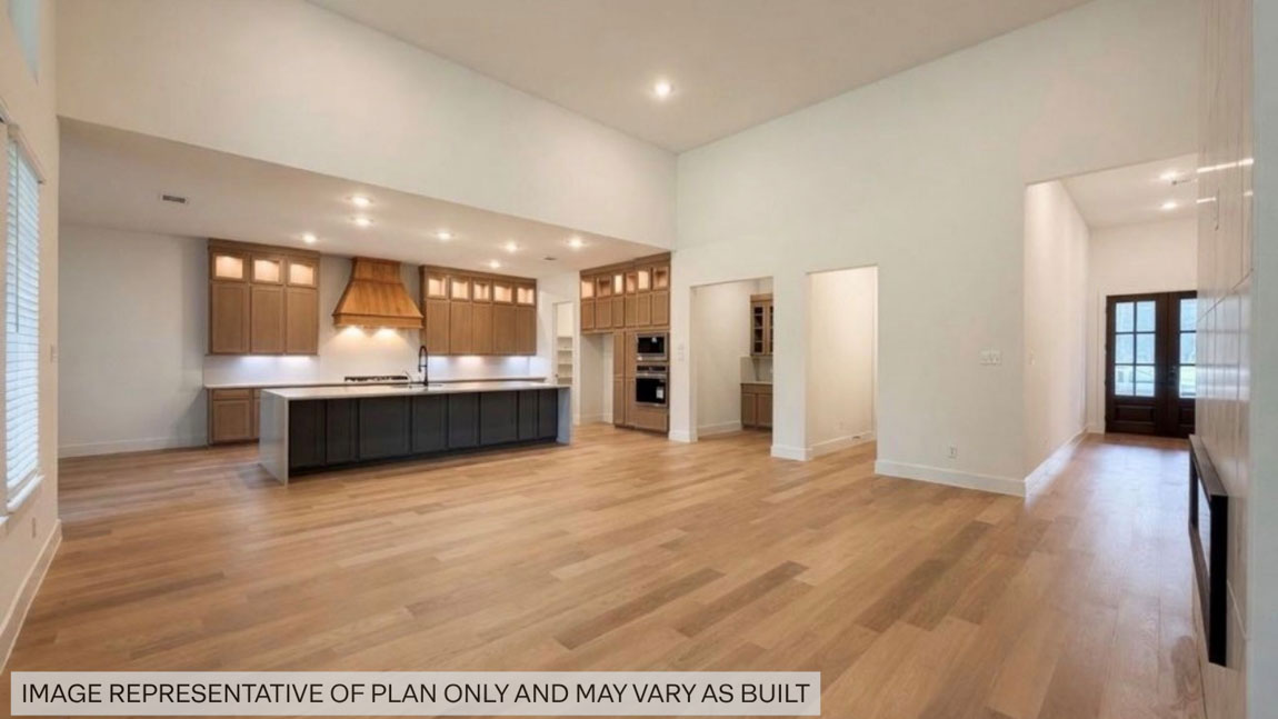 Kitchen with stainless steel appliances, quartz countertops and modern hardware and an island and vinyl floor