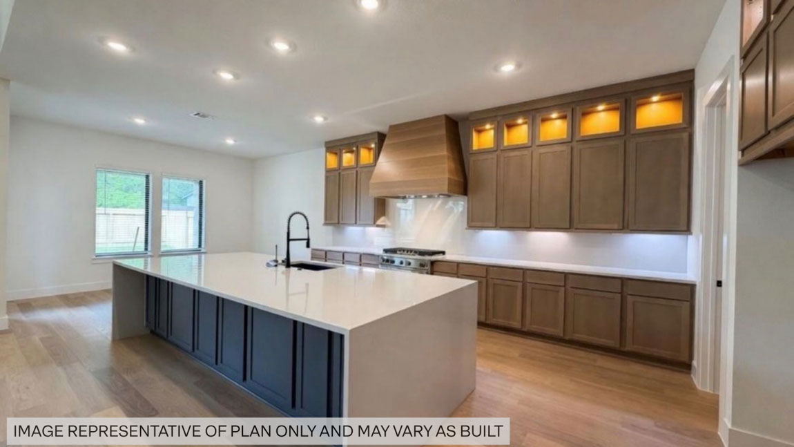 Kitchen with stainless steel appliances, quartz countertops and modern hardware and an island and vinyl floor