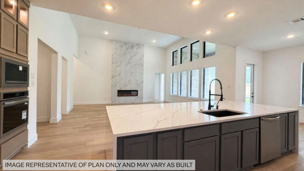 Kitchen with stainless steel appliances, quartz countertops and modern hardware and an island and vinyl floor