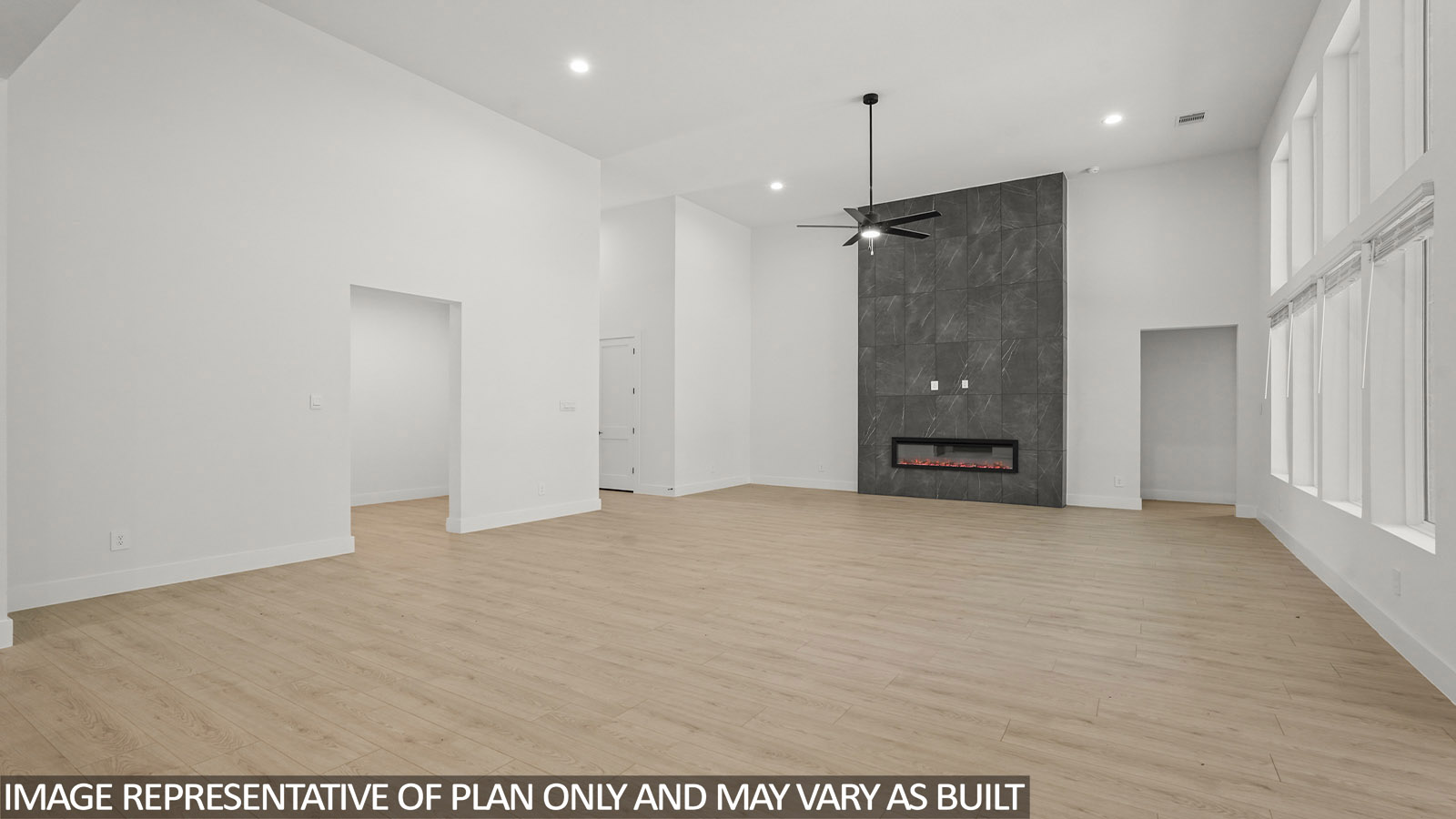 Open concept living, dining, and kitchen area with vinyl flooring and bright windows with floor to ceiling fireplace