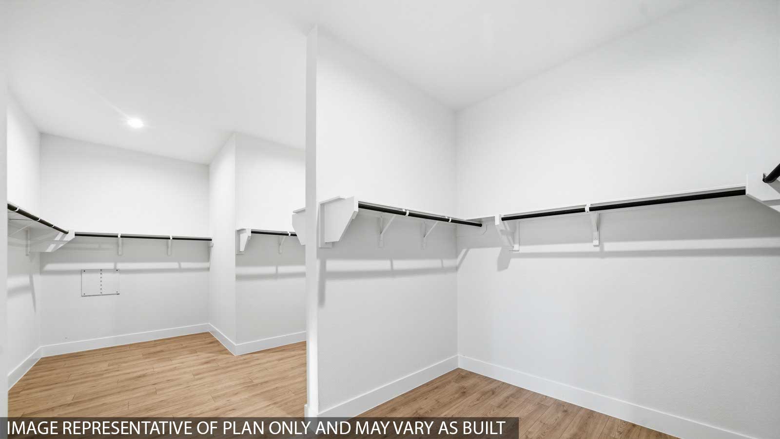Primary bedroom walk-in closet with vinyl flooring in Butlers Bend Estates community in Pinehurst  TX