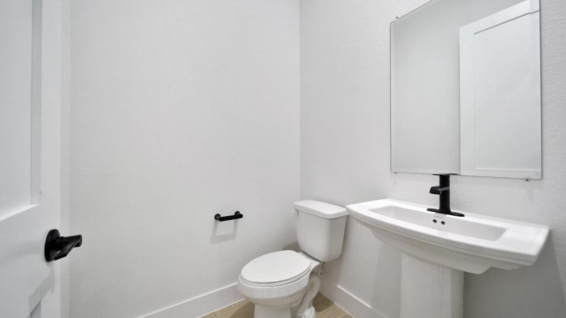 Powder bathroom with pedestal sink right off the foyer entry hallway