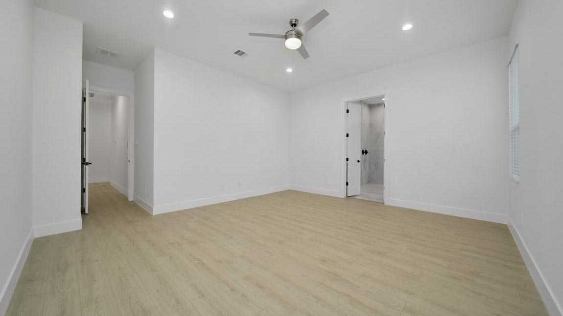 Large Primary bedroom with ceiling fan, vinyl flooring and bright window