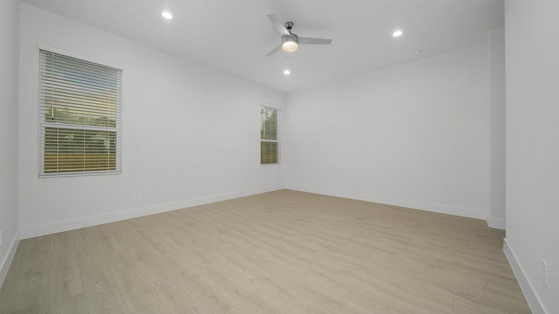 Large Primary bedroom with ceiling fan, vinyl flooring and bright window