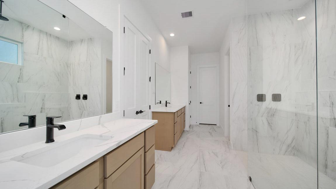 Primary bathroom with super shower with tiled wall and semi frameless glass in Pinehurst  TX