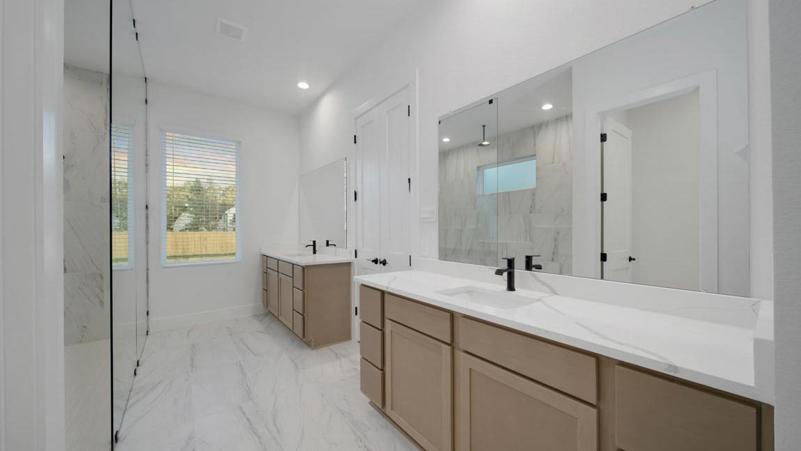 Primary bathroom with super shower with tiled wall and semi frameless glass in Pinehurst  TX