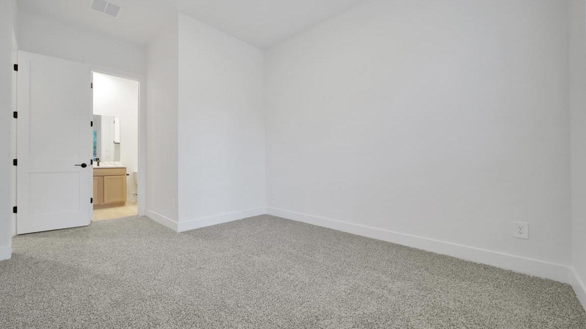 Secondary bedroom with shag carpet flooring and bright window