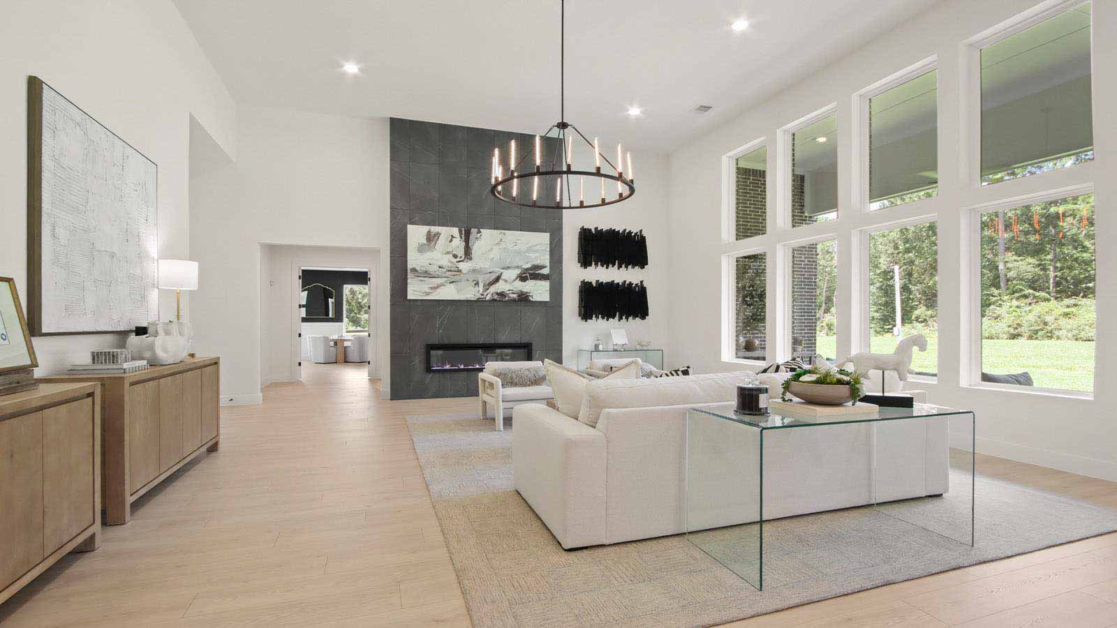 Open concept living, dining, and kitchen area with vinyl flooring and bright windows with floor to ceiling fireplace