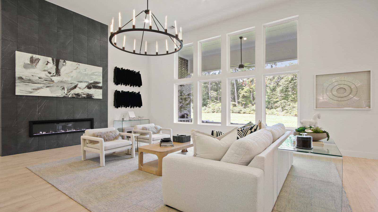 Open concept living, dining, and kitchen area with vinyl flooring and bright windows with floor to ceiling fireplace