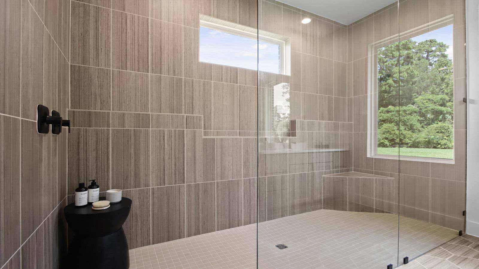 Primary bathroom with super shower with tiled wall and semi frameless glass in Pinehurst  TX