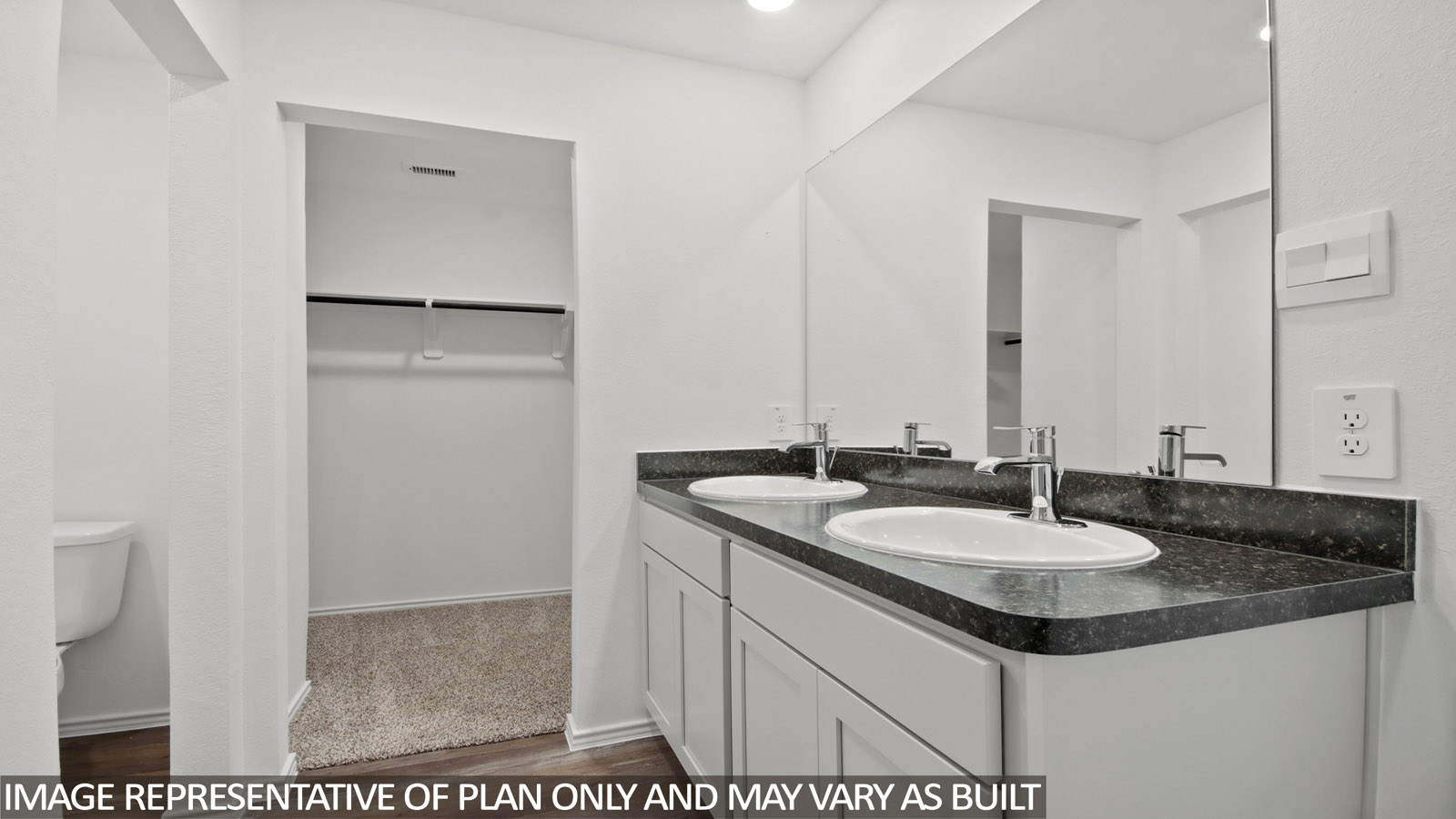 Primary bathroom with a double sink and a walk-in closet.
