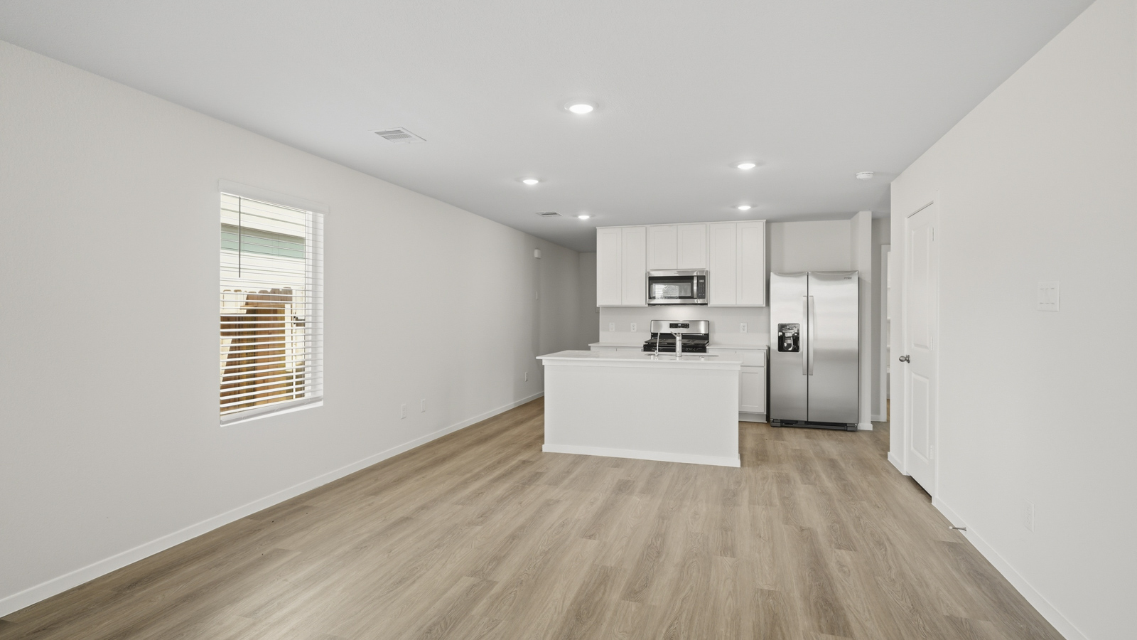 open concept living and dining area with vinyl flooring, quartz countertops, and stainless steel appliances