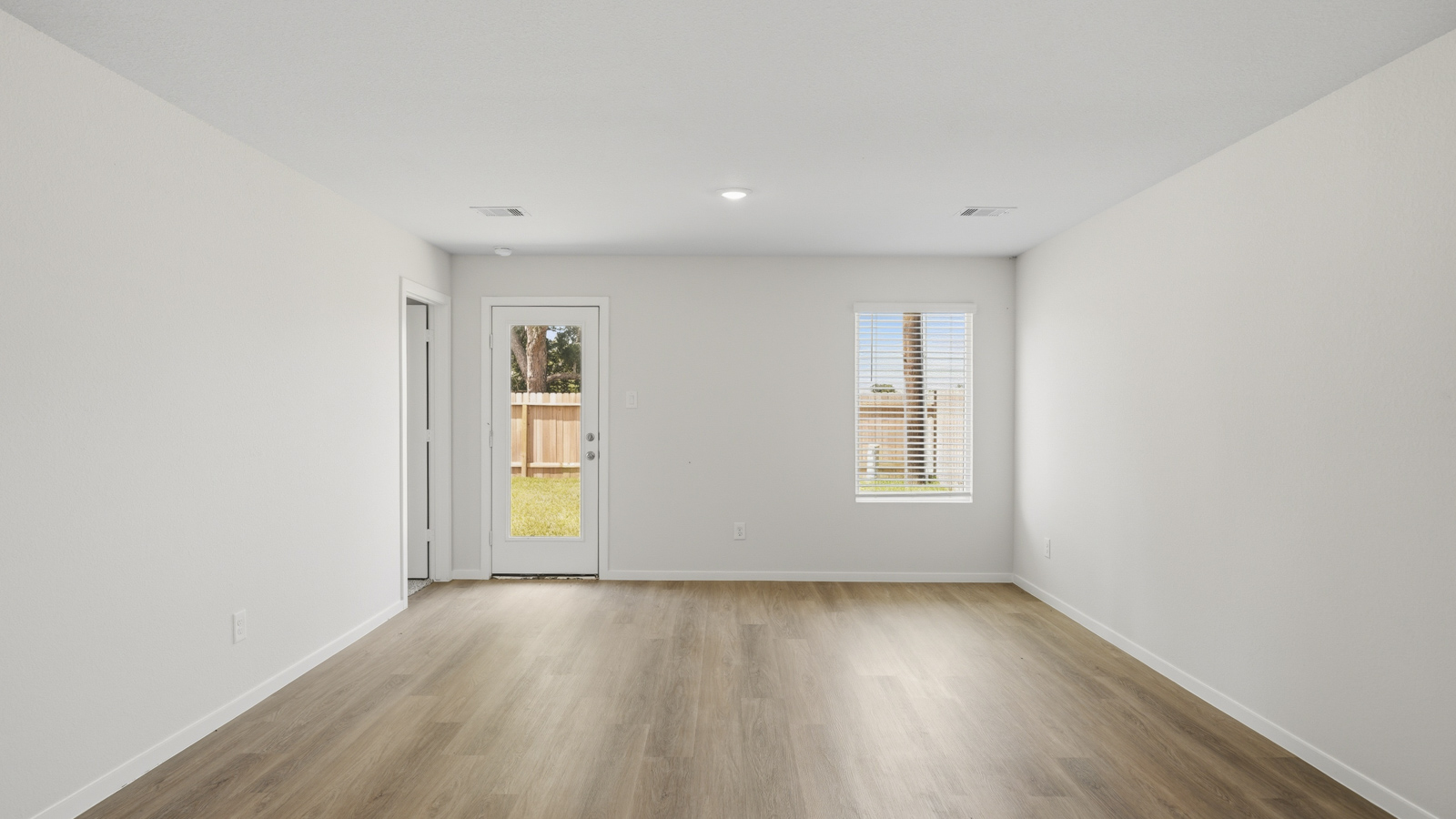 open concept living and dining area with vinyl flooring, quartz countertops, and stainless steel appliances