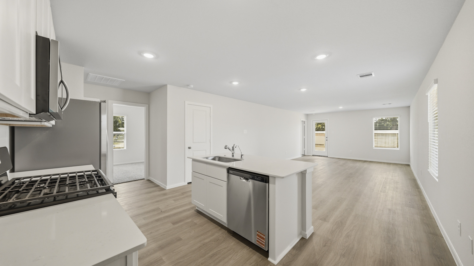open concept living and dining area with vinyl flooring, quartz countertops, and stainless steel appliances