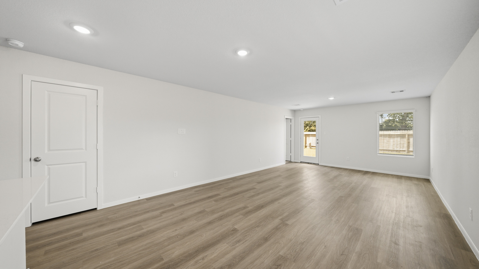open concept living and dining area with vinyl flooring, quartz countertops, and stainless steel appliances