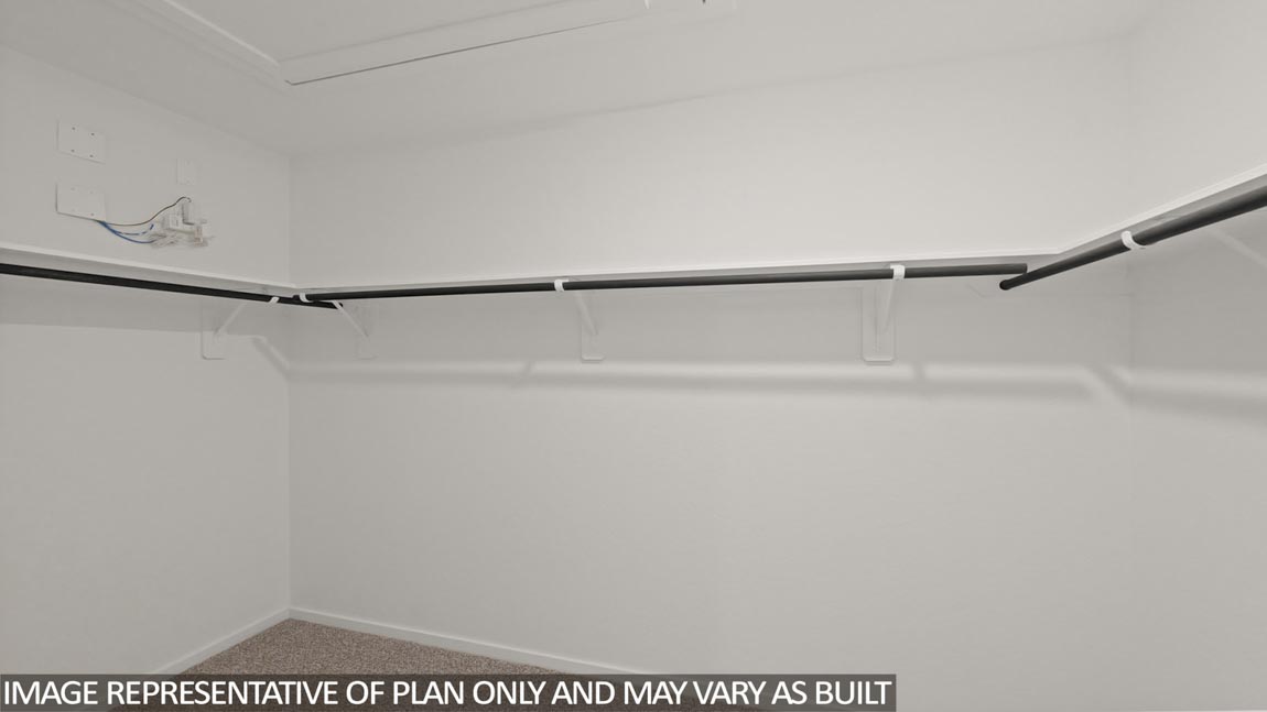 Primary bedroom walk-in closet with carpet flooring in Sunset Valley community in Hockley TX