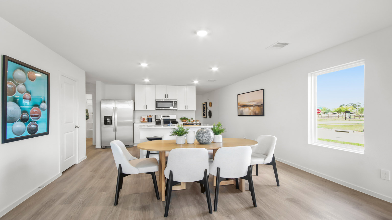 open concept livving and dining area with vinyl flooring and large windows