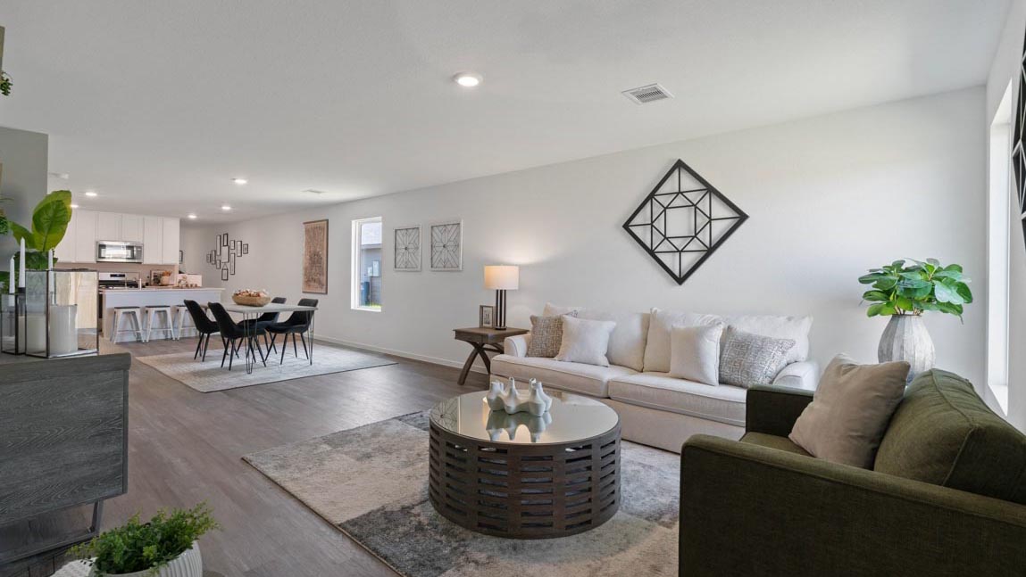 open concept livivng and dining area with vinyl flooring, quartz countertops, and large windows