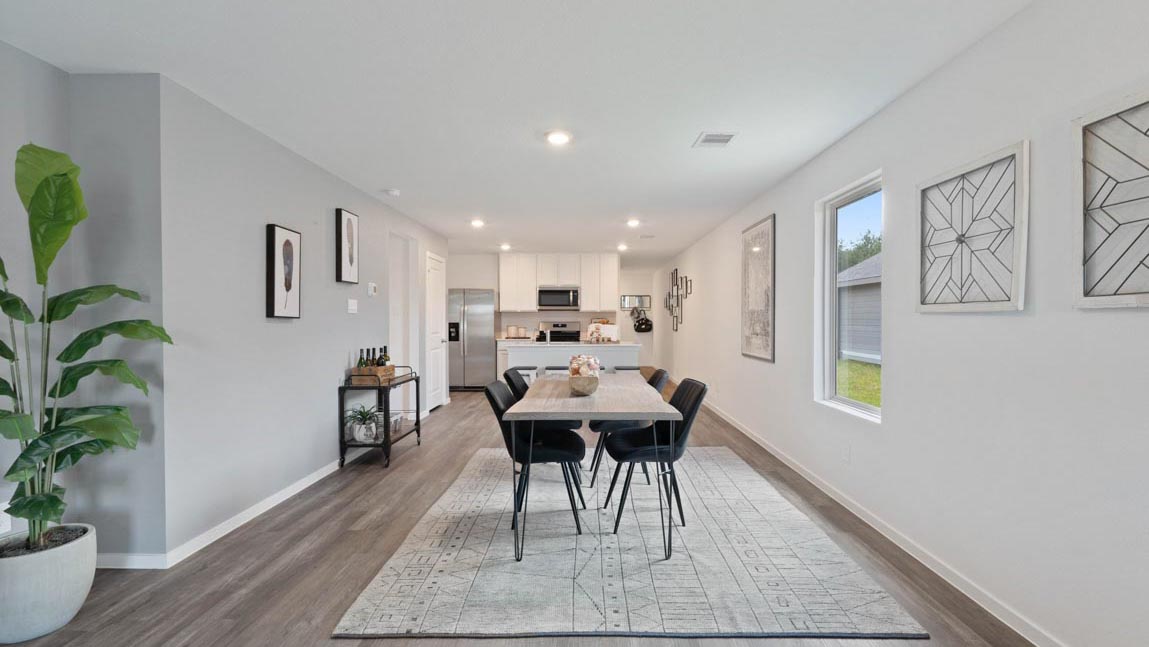 open concept livivng and dining area with vinyl flooring, quartz countertops, and large windows