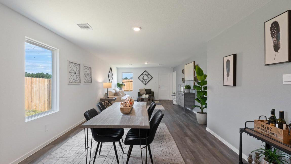 open concept livivng and dining area with vinyl flooring, quartz countertops, and large windows