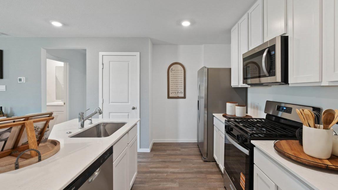 Kitchen with quartz countertops, modern hardware and an island and vinyl floor