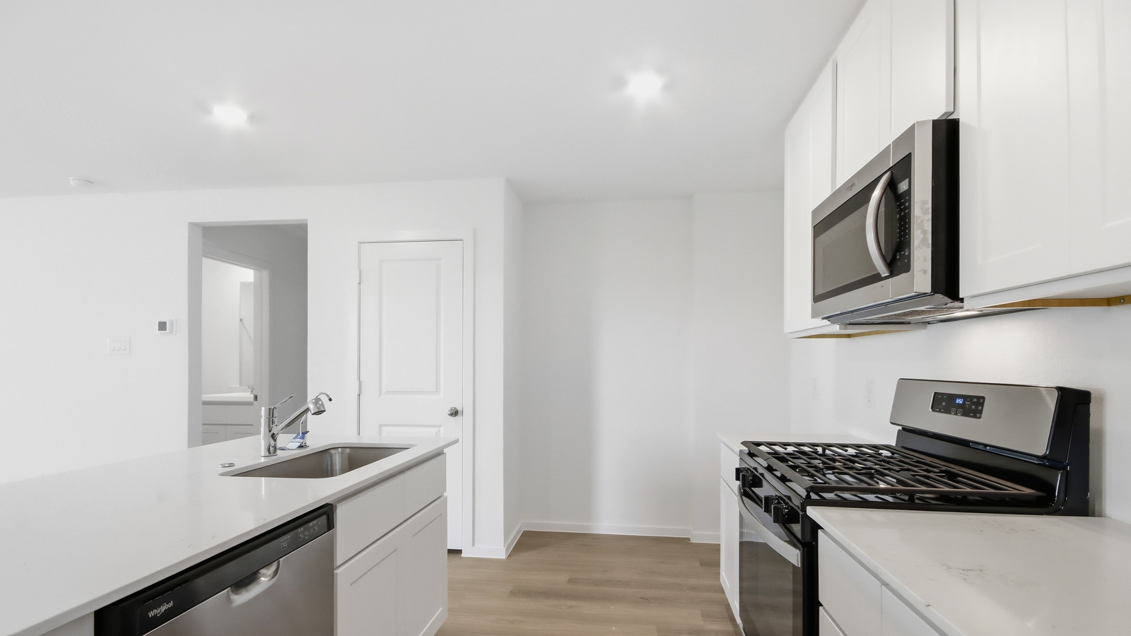 open concept living area with vinyl flooring, large windows, and quartz countertops