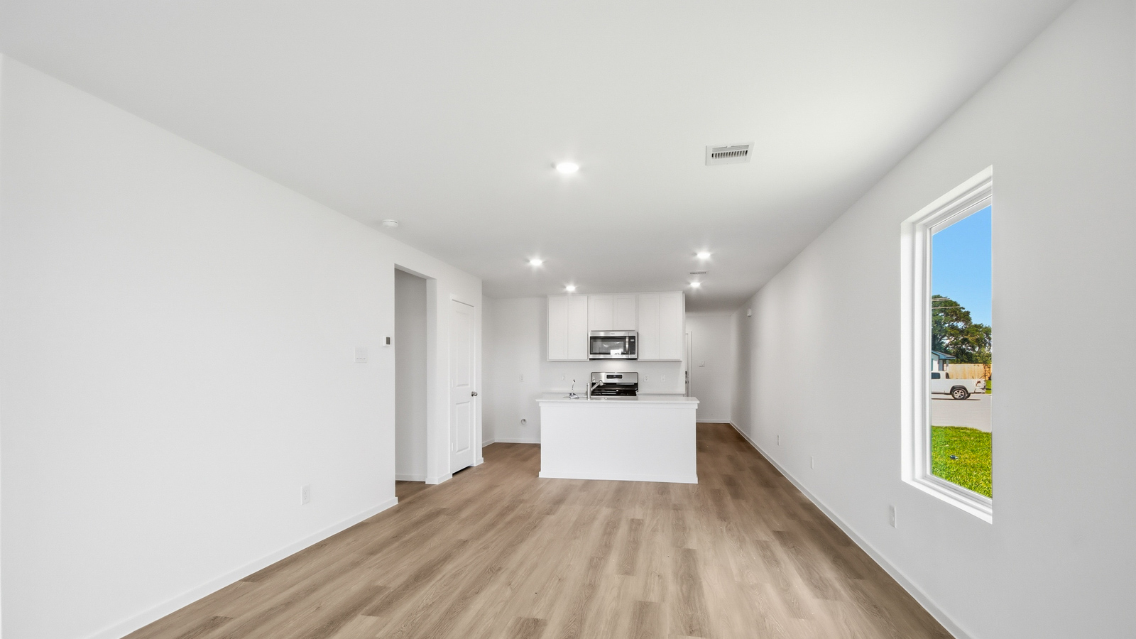 open concept living area with vinyl flooring, large windows, and quartz countertops
