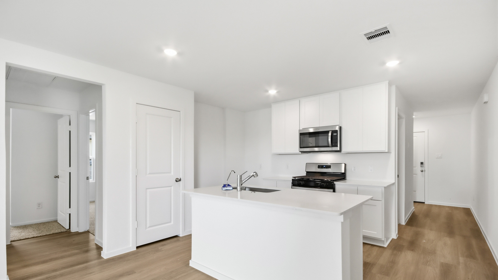 open concept living area with vinyl flooring, large windows, and quartz countertops