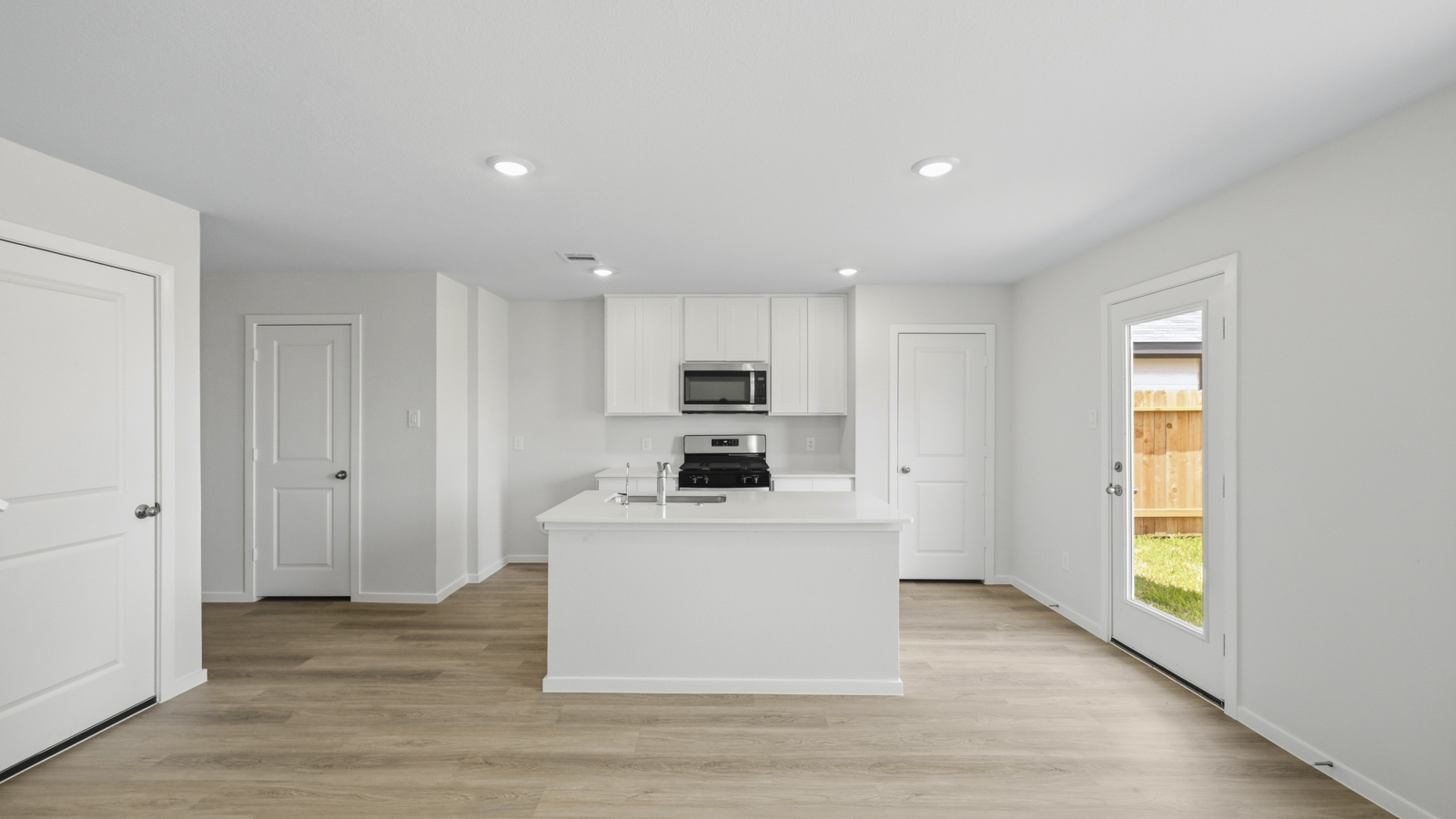 open concept living and dining area with vinyl flooring, large windows, and quartz countertops
