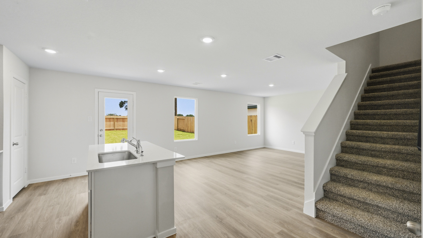 open concept living and dining area with vinyl flooring, large windows, and quartz countertops