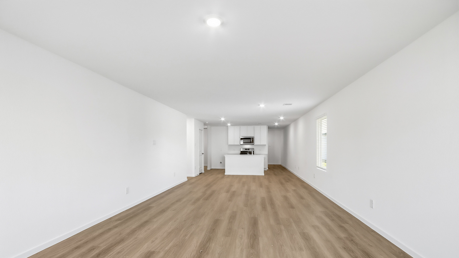 open concept living and dining area with vinyl  flooring, large windows, and quartz countertops