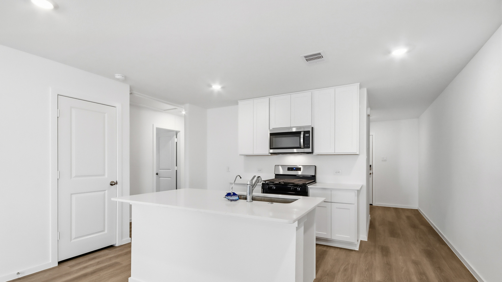open concept living and dining area with vinyl  flooring, large windows, and quartz countertops