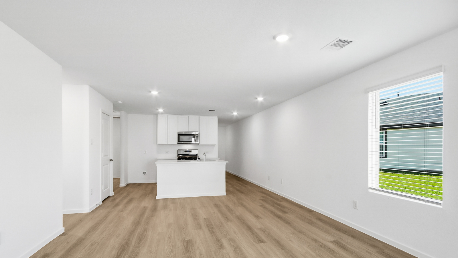 open concept living and dining area with vinyl  flooring, large windows, and quartz countertops