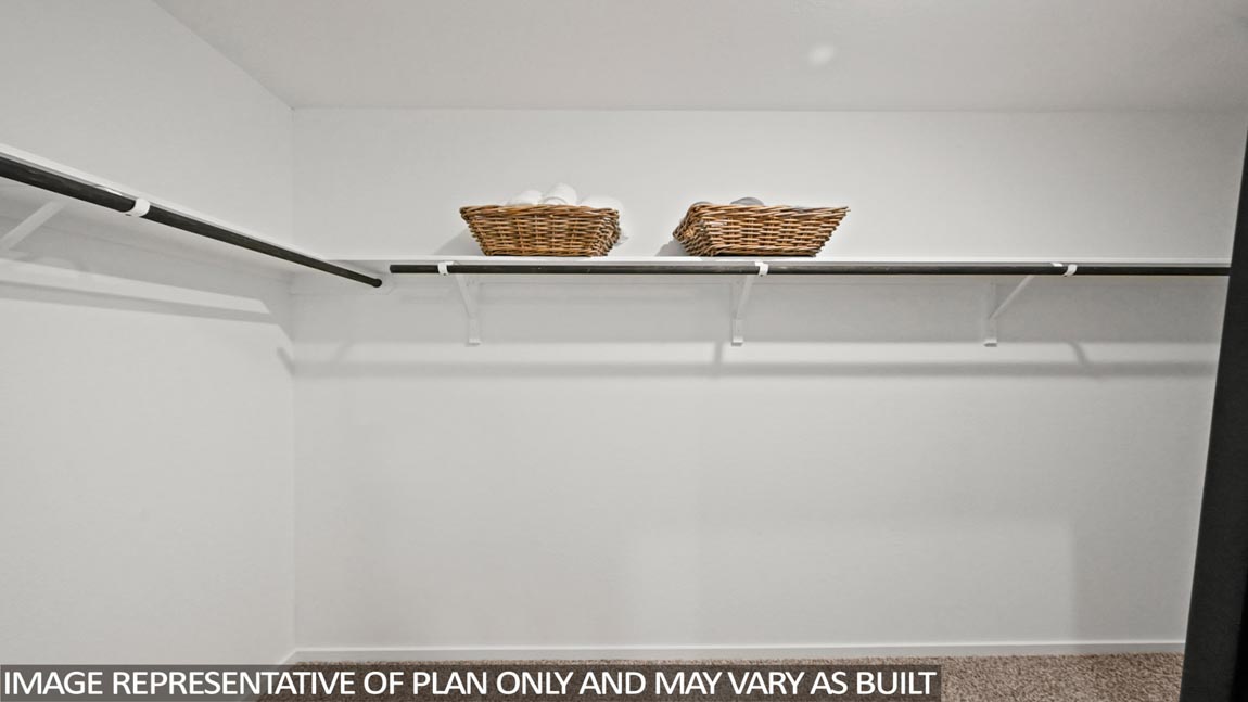 Primary bedroom walk-in closet with carpet flooring in Sunset Valley community in Hockley TX