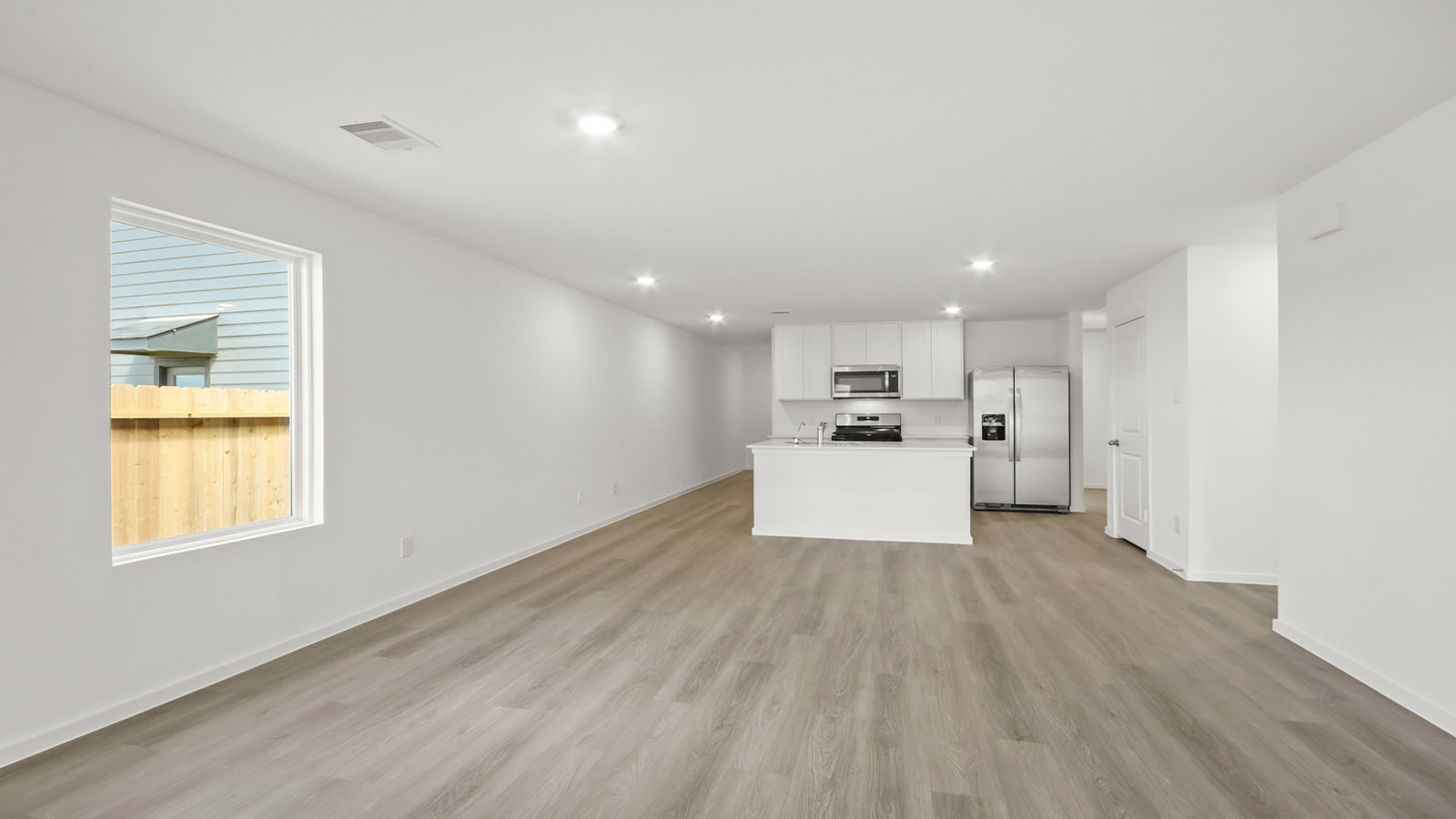 open concept living and dining area with vinyl flooring and large windows