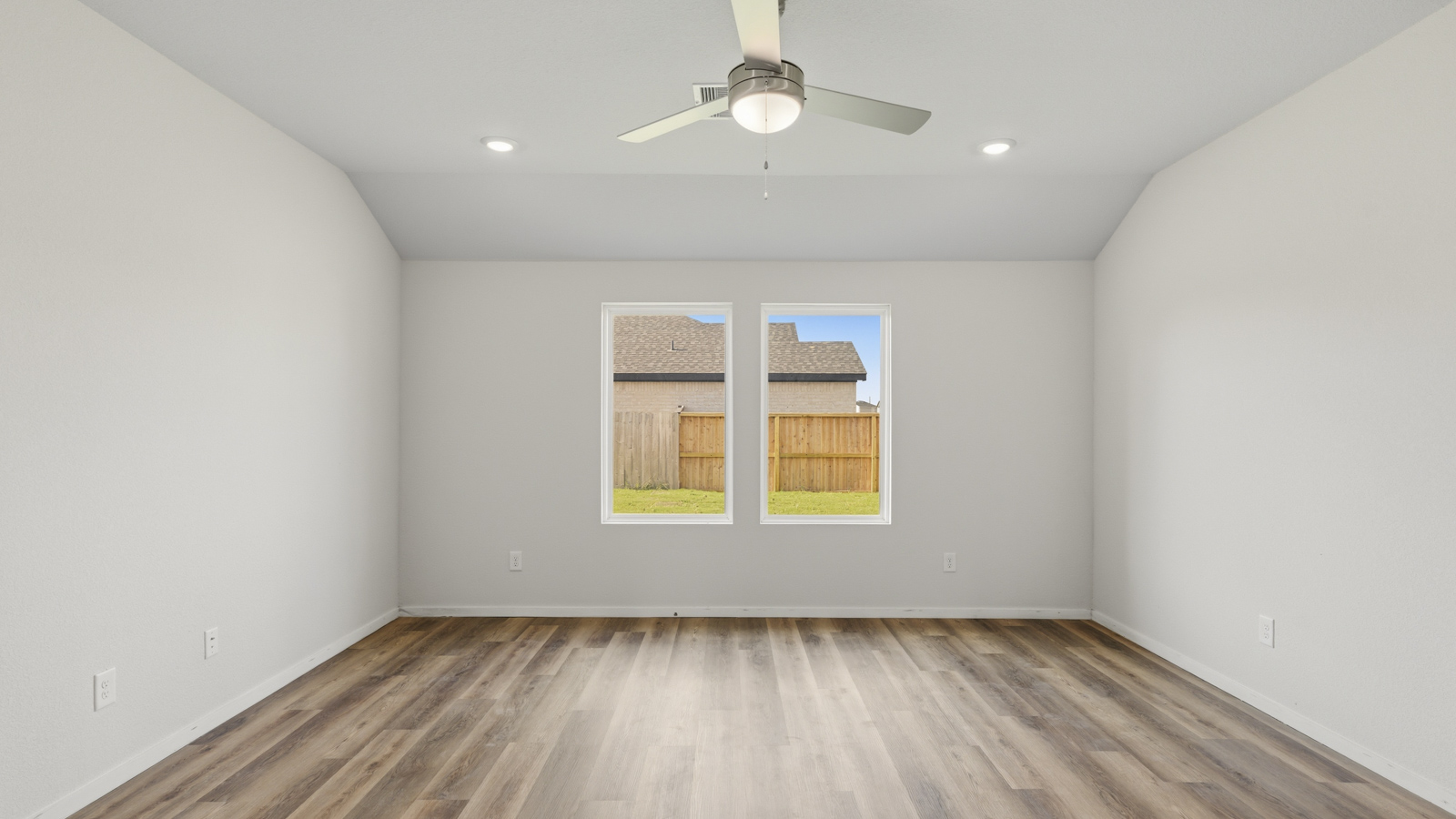 Open concept living and dining area with vinyl flooring and large windows in Brookshire, TX