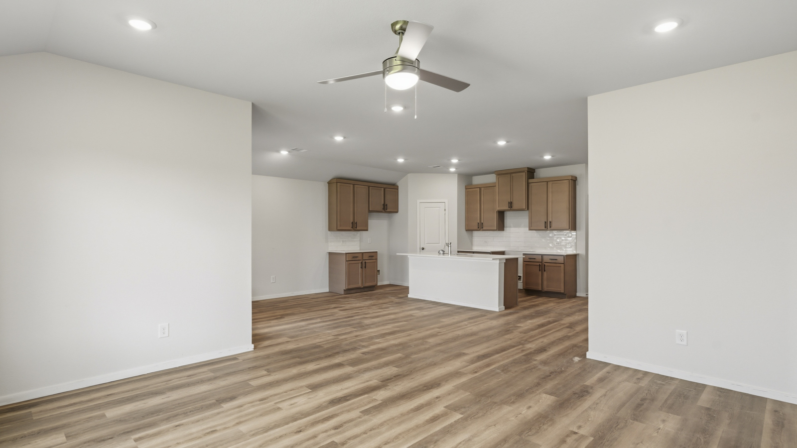 Open concept living and dining area with vinyl flooring and large windows in Brookshire, TX
