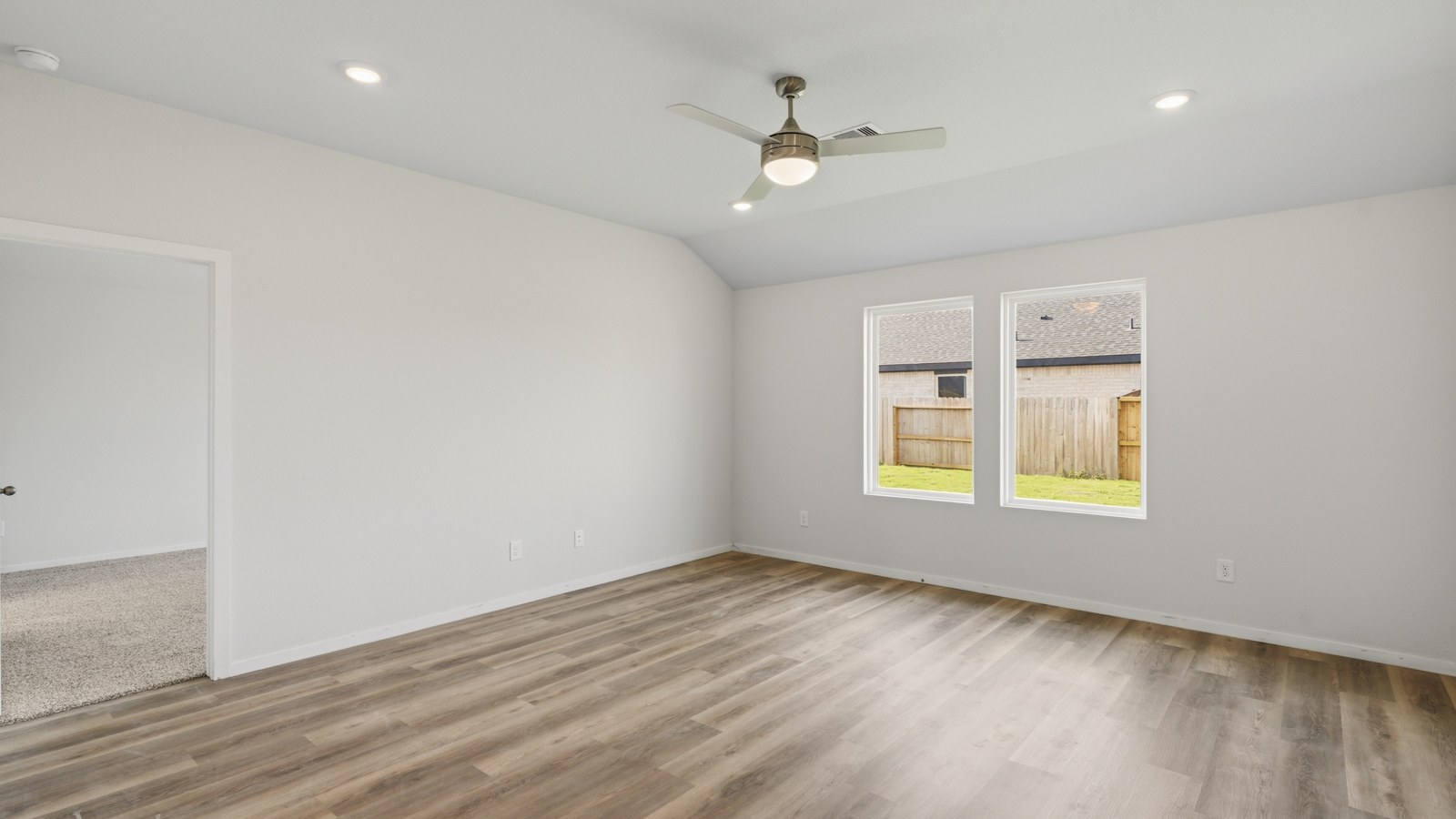 Open concept living and dining area with vinyl flooring and large windows in Brookshire, TX