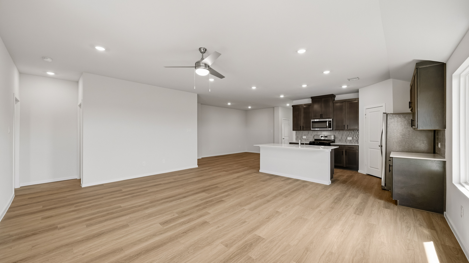 open concept living and dining area with vinyl flooring and large windows in Brookshire, TX