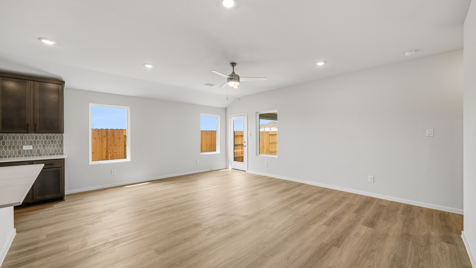open concept living and dining area with vinyl flooring and large windows in Brookshire, TX