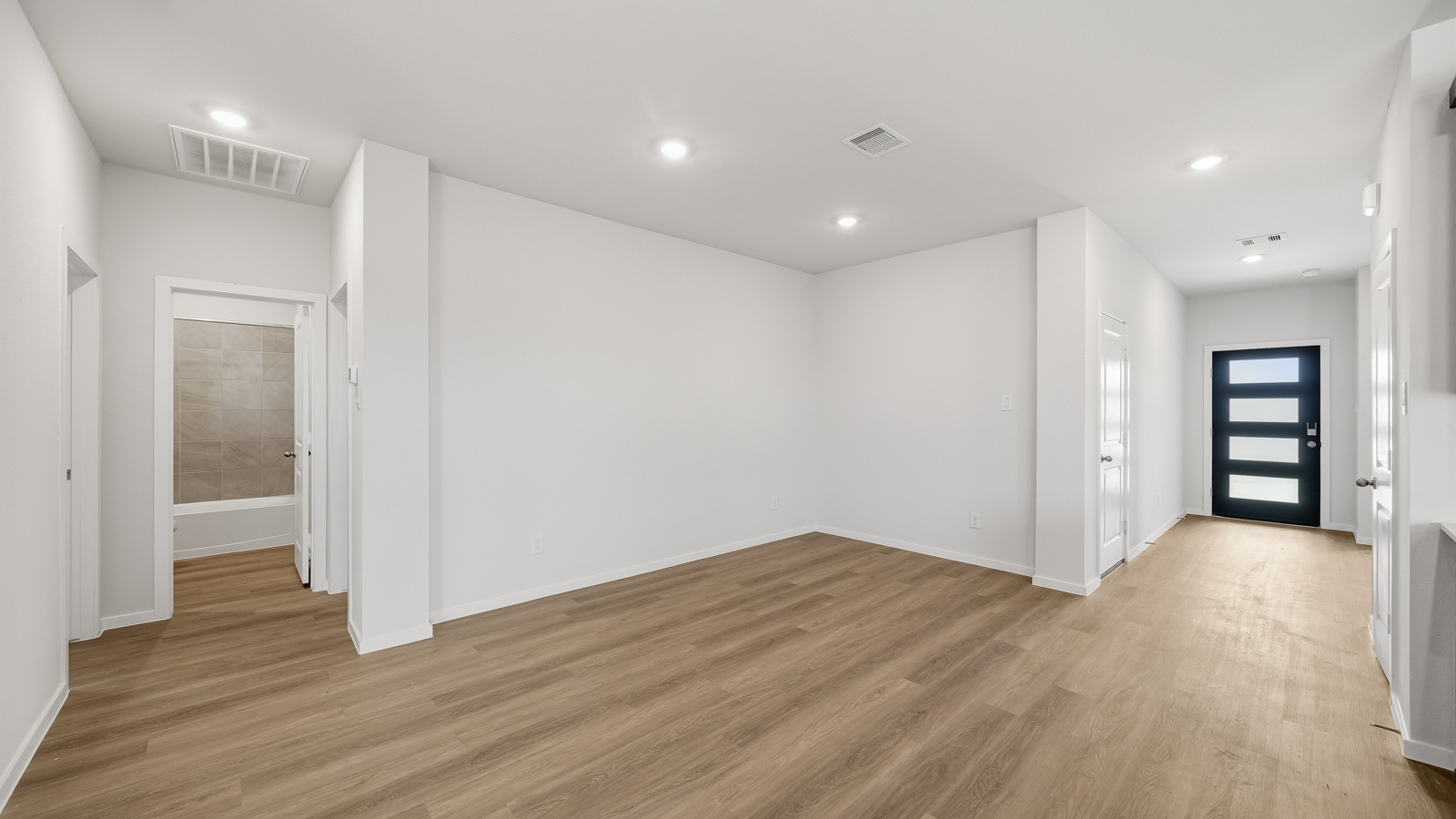 open concept living and dining area with vinyl flooring and large windows in Brookshire, TX