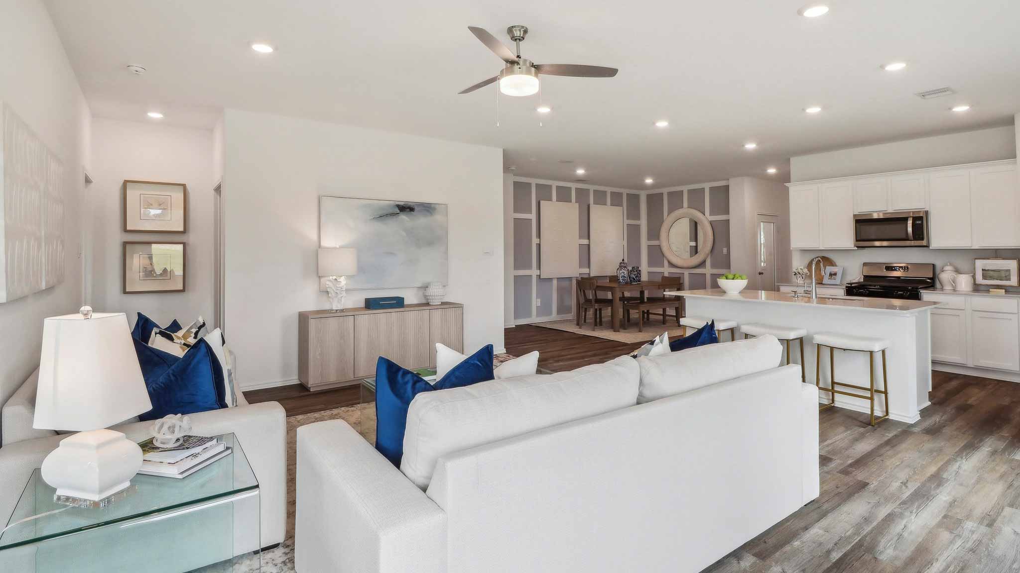 open concept livivng and dining area with vinyl flooring, quartz countertops, and large windows